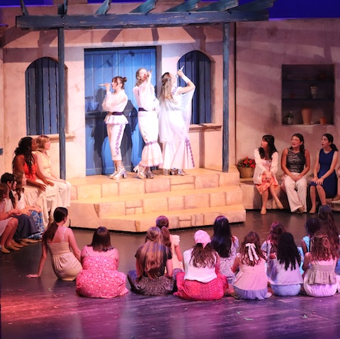 students singing in a musical on stage
