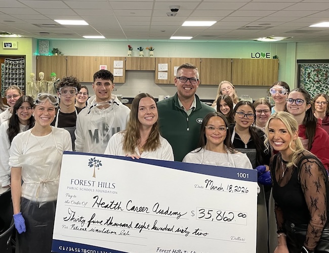 students and staff posing with a giant check to the health cancer academy for 35,862 dollars