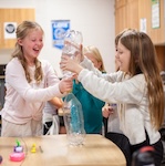 young female students doing an experiment with water