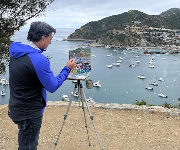 Man painting a bay of boats